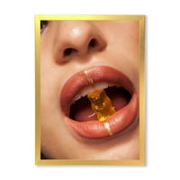 Designart 'zatvori pogled na ženske usne koje grizu gumenog medvjeda' moderni uokvireni umjetnički Print